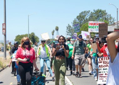 Alameda, CA - July 10, 2022: Youth Led Protesters holding signs protesting SCOTUS overturning Roe, removing abortion rights. Yelling while marching  to City Hall for a rally.