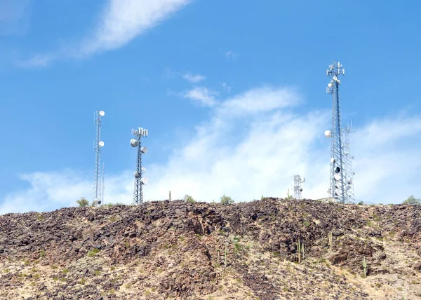 Desert Antenna Repeater Towers,  Communications Towers. Blue sky with clouds in background.