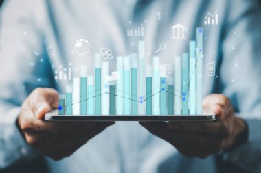 Tablet tablet analitik ve finans çizelgesi tutan işadamı, yeni planlama, iş büyümesi, fikirler ve perspektiflerde değişiklikler, hisse senedi yatırımları ve yeni yılda işten elde edilen kazanç.