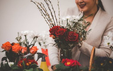 Ev konseptinde çiçek düzenlemeleri öğretirken, Asyalı kadın gülümseyen çiçekçi video yayını ya da akıllı telefon ya da bilgisayar kursu, düzenlenmiş çiçek dekorasyonları, çevrimiçi çiçekçi dükkanı.