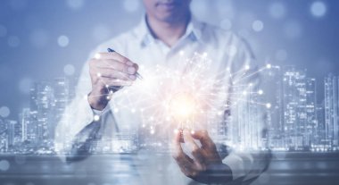 İş adamının elinde ikonlarla ampul tutarak masanın üzerinde çalışması, yaratıcılık ve yenilik başarının anahtarlarıdır. Enerji ve güçle yeni fikir ve yenilik kavramı.