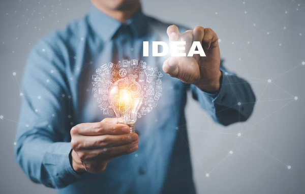 商务人员手握线形灯泡 在办公桌前工作 创造力和创新是成功的关键 — 图库照片