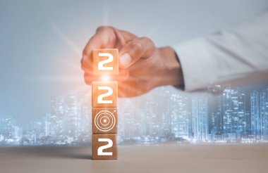 Yeni yıl 2022 'de başarılı bir işe başlamak, işe başlamak, 2022' de tahta küpleri tutmak ve hedef veya hedef ikon olmak. Yeni Yıl kavramı İş hedefleri ve vizyon.