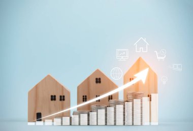 Paralar ahşap ev ve ok işinin önüne istiflenir, para tasarrufu konsepti, emlak yatırımı, ev kredisi, ters ipotek, altın sikkeler para yığını büyümesi, para biriktirme ev için gelecek istifleme 