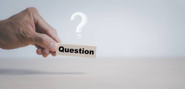 Elle tutulur tahta küp bloğu soru işareti ile çimento masa arka planında ne anlama gelir, soru işareti olan tahta bloklar sütunu. kopyalama alanı, SSS sıklıkla sorulan sorular, Yanıt, Bilgi