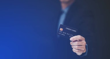 İş adamı kredi kartı tutuyor ve cep telefonu kullanıyor. Çevrimiçi alışveriş kavramı, bankacılık ve çevrimiçi alışveriş. Kapatın..