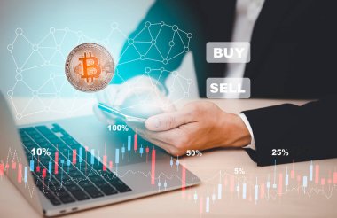 Bitcoin konsepti yığınları arasında ekranda Bitcoin grafiği olan akıllı telefon. İşadamı, hisse senedi piyasası, kripto para ve finans üzerinde büyük satın alma ve satış düğmeleri ile mobil uygulama ekranına dokundu.