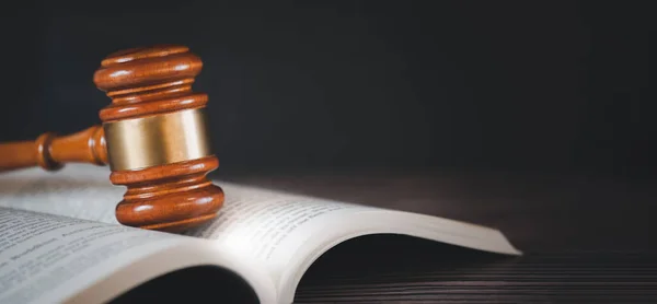 Old wood Judge hammer with law book on the table wood background, Used for adjudication and Justice.