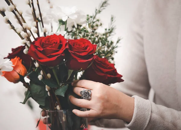 Çevrimiçi ev çiçekleri düzenleme konsepti, kırmızı ve pembe gülleri budamaya hazırlanan kadın ve evdeki güzel çiçek düzenlemeleri, Sevgililer Günü için hediye olarak vazo ile çiçek düzenlemeleri. 