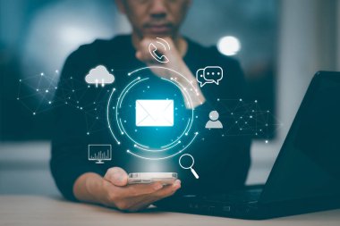 Businessman hold smartphone with Email of communication icons, letter icon, email icons, and newsletter email and protects your personal information or spam mail, Customer service call center contact.