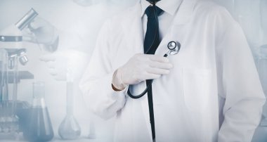 Doktor ya da steteskoplu bir doktor ya da bilim adamı, tıbbi maske ve eldiven takıyor, kalp seslerini, sağlık ve tıbbı dinlemek için steteskop kullanıyor, laboratuvarda aşı buluyor..