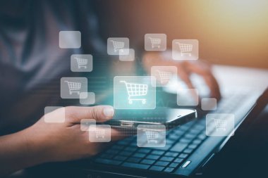 Hand hold smartphone with  typing on keyboard with online shopping concept, Shopping cart part of the network in hand, Innovation in e-Commerce, Online shopping business with selecting shopping cart.