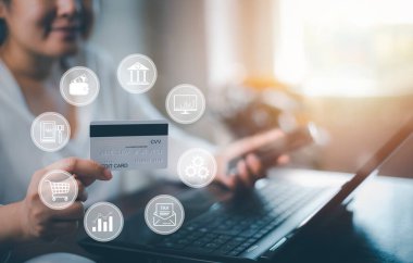 Woman holding credit card for makes a purchase on the Internet on the laptop computer with credit card, online payment, shopping online, e-commerce, internet banking, spending money concept.