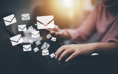 Businesswoman holding smartphone with communication icons, letter icon, email icons, and newsletter email and protect your personal information or spam mail, Customer service call center contact.