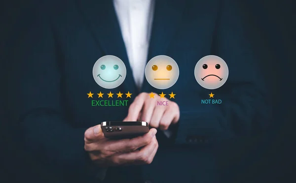 Happy and unhappy Smiley face concept Customer service evaluation concept. smiling Asian female Is using a smartphone, woman is pressing face emoticon smiling in satisfaction on virtual touch screen.