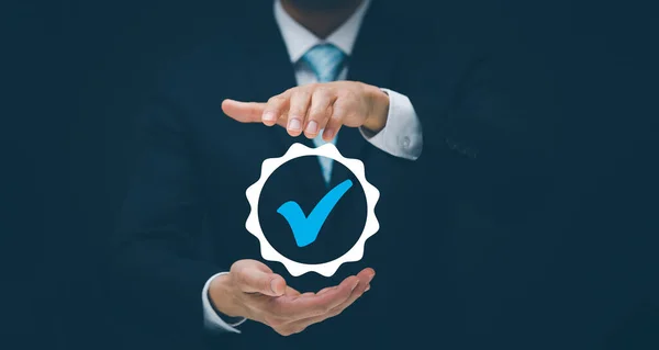Quality assurance of business services, Businessman Hand shows the sign of the top service Quality assurance in Black background , Guarantee, Standards, ISO certification and standardization concept.