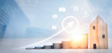 Paralar ahşap ev ve ok işinin önüne istiflenir, para tasarrufu konsepti, emlak yatırımı, ev kredisi, ters ipotek, altın sikkeler para yığını büyümesi, para biriktirme ev için gelecek istifleme 