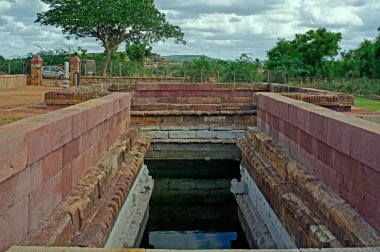 06 06 2008 Aihole 7. C / Hindu-Aihole Karnataka-INDIA 'daki Huchchimalli Gudi veya Temple' da açık mavi gökyüzü ve yeşil yeşillik altında su tankı.