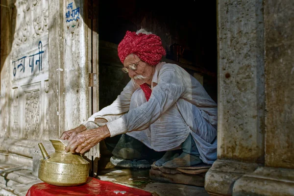 印度拉贾斯坦邦普什卡牛交易会 头戴红色头巾清洁黄铜器皿喝水的老人 — 图库照片