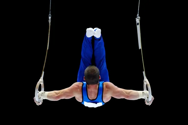 Gymnasten utför på ringar Stockfoto