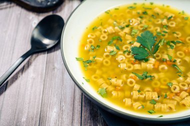 Enfes tavuk ve sebze çorbası. Evde yapılan küçük erişte ve maydanozlu. Üst görünüm, boşluğu kopyala. Doğal ve sağlıklı gıda konsepti