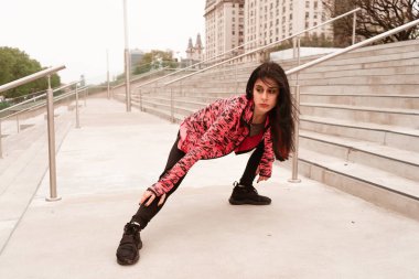 Genç siyah saçlı atlet kadın koşmaya ve egzersiz yapmaya başlamak için ısınıyor ve ısınıyor. Dolu hayat kavramı, doğal ve sağlıklı hayat. Kadın sporları.