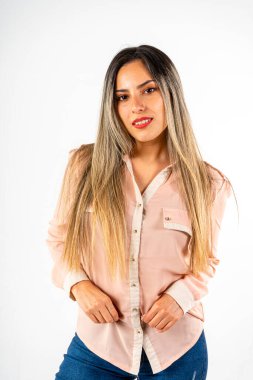 Güzel, gülümseyen bir Latin kadının dikey oryantasyonuyla orta çekim. Elleri önde ve beyaz bir arkaplanda ileriye bakıyor. Terfi için sağda fotokopi var. Mutluluk, başarı, mutluluk kavramı.