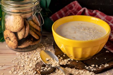 Bir kase süt ve yulaf ezmesi ve bir kavanoz kuru üzümlü kurabiye..