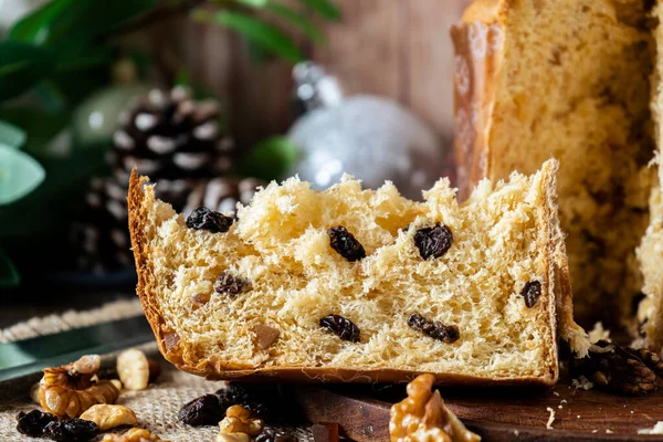 Close-up of a portion of sweet bread or Italian panettone with dried fruits inside.