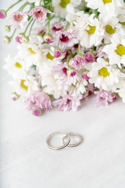 Pair Wedding Rings White Surface Beautiful White Purple Flowers Background — Stockfoto