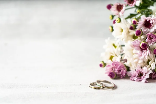 Pair Wedding Rings White Surface Beautiful White Purple Flowers Edge — Stockfoto