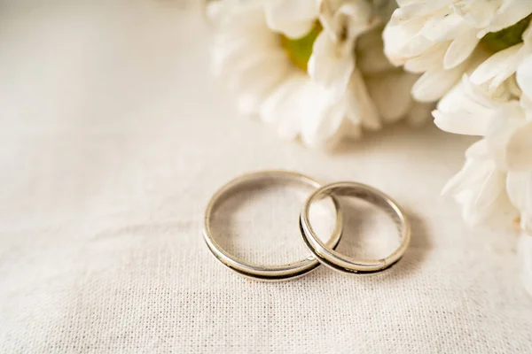 Pair Wedding Rings White Surface Beautiful White Flowers Commitment Love — Stockfoto