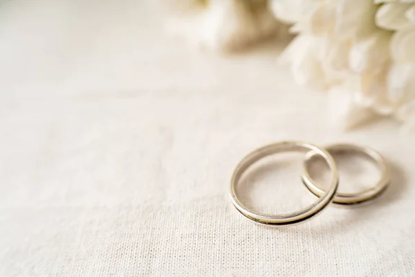 Pair Wedding Rings White Surface Beautiful White Flowers Commitment Love — Stockfoto