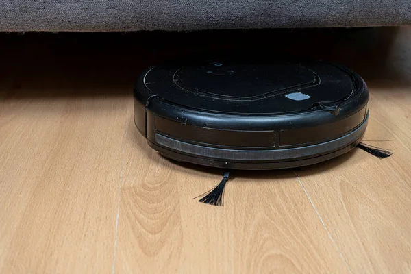 Robot Vacuum Cleaner Cleaning Sofa Normal View — стоковое фото
