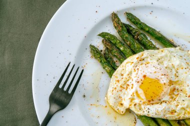 Baharatlı ve baharatlı kızarmış yumurta ile hazırlanmış nefis bir kuşkonmaz. Doğal mutfak, gurme..