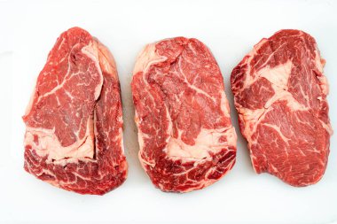 Beyaz arka planda üç çiğ kaburga bifteği. Yemek konsepti. genel görünüm.