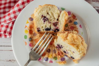 Enfes ev yapımı kek ya da yaban mersini ve böğürtlenli kek kırsal bir masada beyaz bir tabakta ikiye bölünmüş. Ev yemeği, doğal yemek..