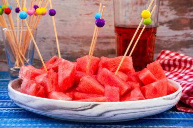 Yemek çubuklarıyla servis tabağında küçük pürüzlü tatlı karpuz parçaları görmek normal. Sağlıklı, taze ve doğal yiyecekler. Mevsim meyveleri.