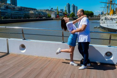 Limandaki bir köprüde yürüyen mutlu genç bir çiftin portresi. Aşk kavramı, çift, mutluluk..