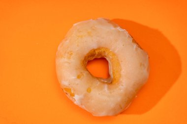 Turuncu bir yüzeye kremayla kaplı geleneksel bir çörek. Turuncu bir yüzeye kremayla kaplı geleneksel bir çörek..