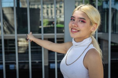 Beyaz tişörtlü, gülümseyen, güzel bir Latin kadının yakın çekimi..