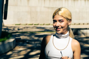 Beyaz tişörtlü, gülümseyen, güzel bir Latin kadının yakın çekimi..