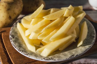 Patates kızartması yapmak için çiğ patates kamışı tabağı. Doğranmış ya da yüksek görüşlü. yakın plan.