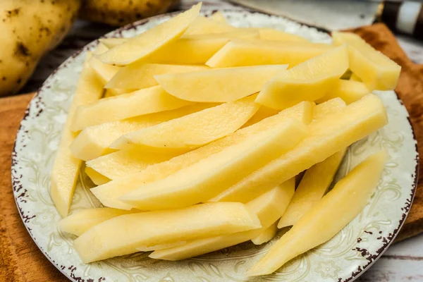 Patates kızartması yapmak için çiğ patates kamışı tabağı. Doğranmış ya da yüksek görüşlü. yakın plan.