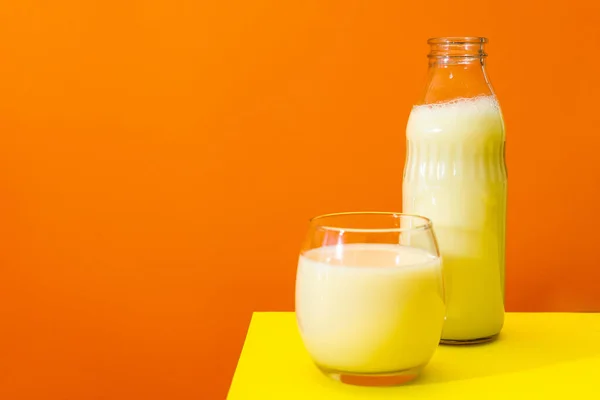 Botella Vidrio Vaso Grande Con Leche Sobre Una Mesa Amarilla — Foto de Stock