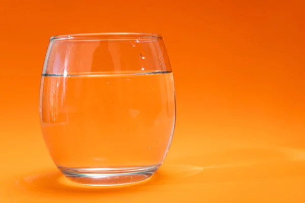 Vaso Vidrio Con Agua Purificada Sobre Fondo Degradado Naranja Naranja — Foto de Stock