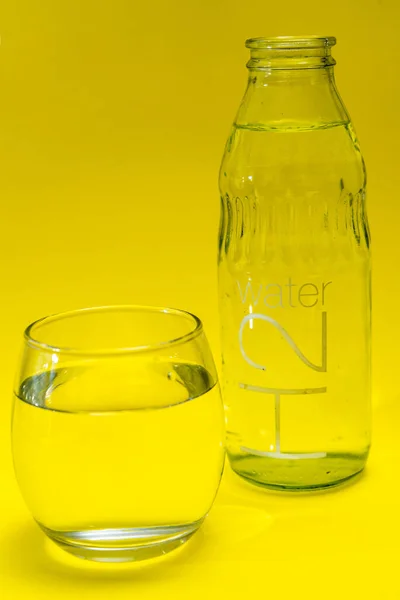 Vaso Precipitados Botella Llena Agua Purificada Fondo Amarillento — Foto de Stock