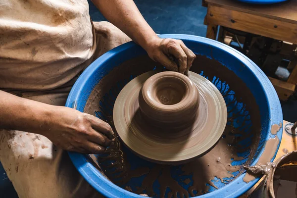 ろくろで土を作る陶芸家の熟練した手 土は陶芸家が粘土のテラコッタのトーンでそれを与える形を取ります — ストック写真