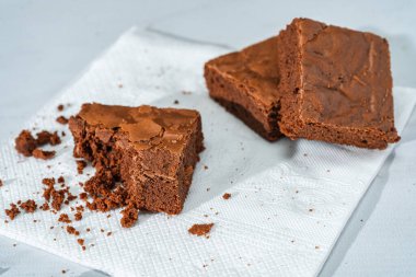 Mermer bir masada beyaz tabakta bir küp çikolatalı brownie..