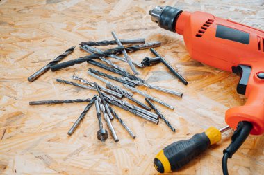 Şantiyedeki bir tezgahta matkabın yanında farklı, karışık matkap uçları var. Konsept inşaat makinesi.